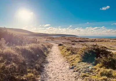 a dirt road in the middle of a field at Delightful two bedroom caravan on Par Beach. in Par