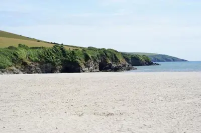 a sandy beach with the ocean in the background at Delightful two bedroom caravan on Par Beach. in Par