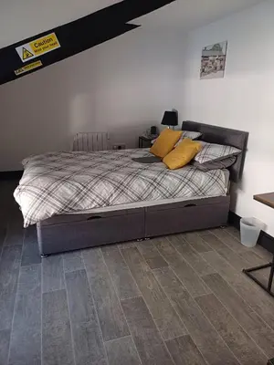 a bedroom with a bed with yellow pillows on it at Commercial Inn in Saint Dennis