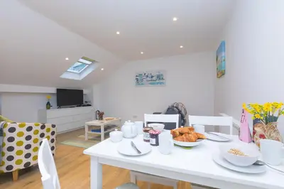 a white table with food on it in a living room at Whitecaps in St Ives