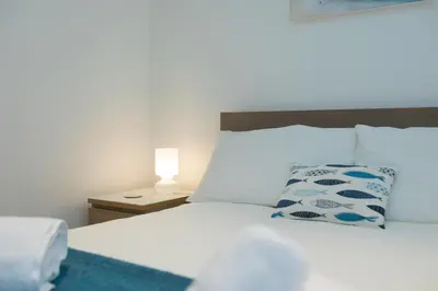 a bed with a pillow and a lamp on a table at Whitecaps in St Ives