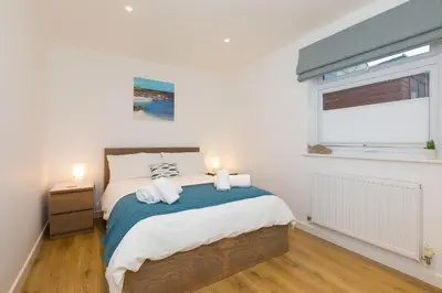a bedroom with a bed with two towels on it at Whitecaps in St Ives