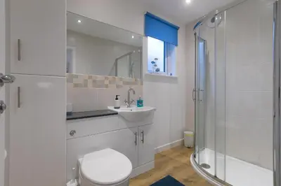 a bathroom with a toilet and a sink and a shower at Whitecaps in St Ives