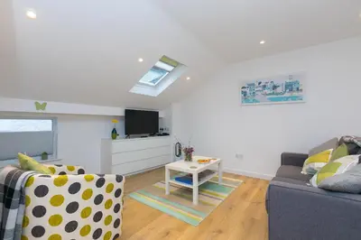 a living room with a couch and a table at Whitecaps in St Ives