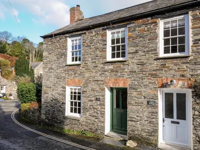 an old stone house with a green door at Lowen Cottage in Boscastle