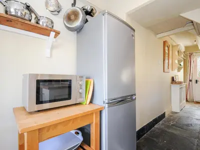a kitchen with a stainless steel refrigerator and a microwave at Lowen Cottage in Boscastle