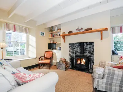 a living room with a fireplace and couches at Lowen Cottage in Boscastle