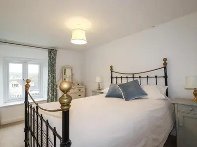 a bedroom with a large bed and a window at Lanvean Farmhouse in Newquay