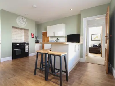 a kitchen with a table and two stools at The Mordon in Newquay