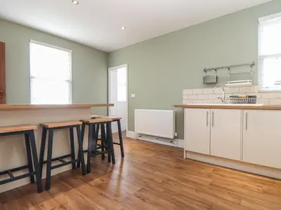 an empty kitchen with wooden tables in a room at The Mordon in Newquay