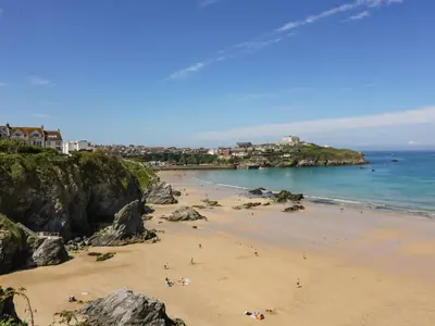 a group of people on a beach near the ocean at The Mordon in Newquay