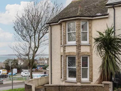 an old brick house with a window on a street at The Mordon in Newquay