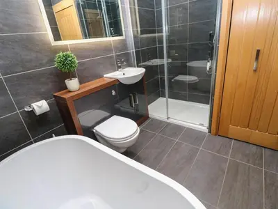 a bathroom with a tub and a toilet and a sink at Rooftops in St Ives