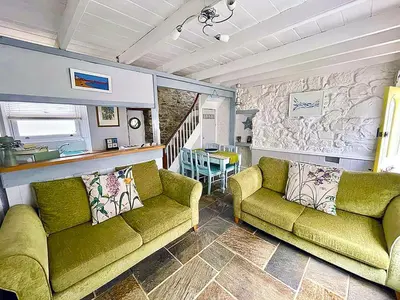 a living room with two green couches and a table at A Cosy Period Family Cottage in St Ives Town, sleeps 4, pet friendly in St Ives
