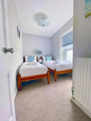 a bedroom with two beds and a window at A Cosy Period Family Cottage in St Ives Town, sleeps 4, pet friendly in St Ives