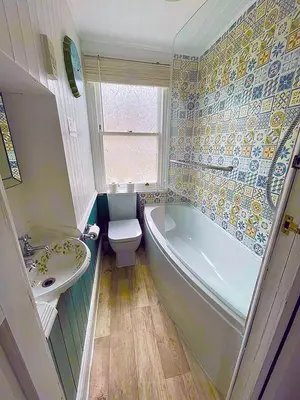a bathroom with a tub and a toilet and a sink at A Cosy Period Family Cottage in St Ives Town, sleeps 4, pet friendly in St Ives