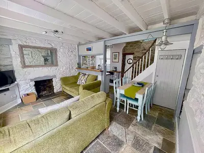 a living room with a couch and a table at A Cosy Period Family Cottage in St Ives Town, sleeps 4, pet friendly in St Ives