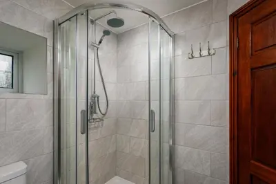 a bathroom with a shower with a glass door at Lanjew Park in Bodmin