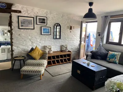 a living room with a couch and a chair at Horseshoe Cottage in Looe