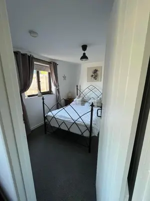 a bedroom with a bed and a window at Horseshoe Cottage in Looe