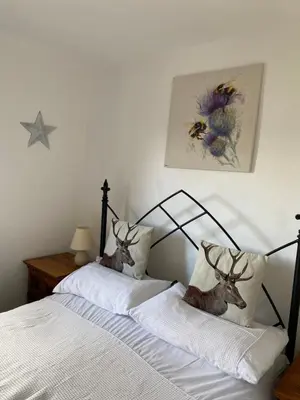 a bedroom with two beds and a picture of a bee at Horseshoe Cottage in Looe
