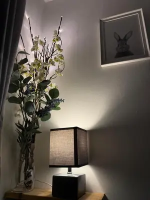 a table with a lamp and a vase with flowers at Horseshoe Cottage in Looe