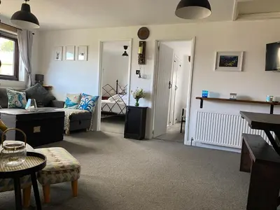 a living room with a couch and a table at Horseshoe Cottage in Looe