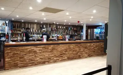 a bar with people sitting at the bar at Woodland bungalow, fantastic location in Uny Lelant