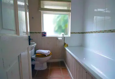 a bathroom with a toilet and a tub and a window at St Ives fisherman cottage, Sleeps 5, pet friendly in St Ives