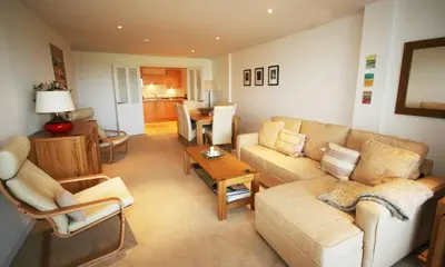 a living room with a couch and a table at Headland View at Bredon Court in Newquay