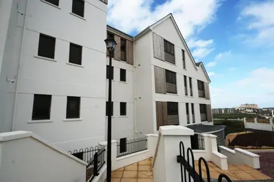 a white building with a street light next to it at Headland View at Bredon Court in Newquay