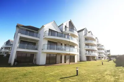 a large white apartment building with a large yard at Headland View at Bredon Court in Newquay
