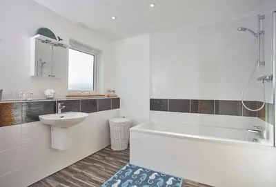 a bathroom with a sink and a tub and a toilet at Little Treveth Lowen in Saint Minver