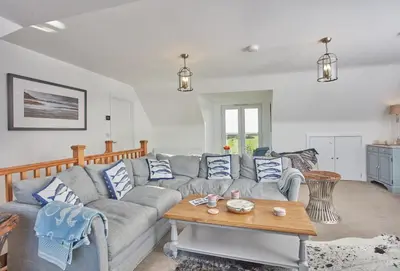 a living room with a couch and a table at Little Treveth Lowen in Saint Minver
