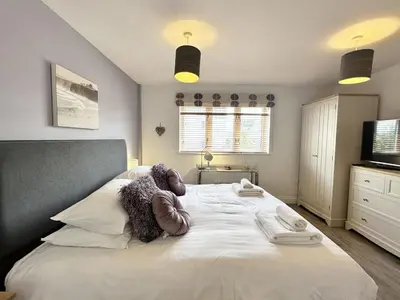 a bedroom with a bed with towels on it at Surf's Up! in Newquay