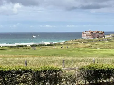 a large building on a hill next to the ocean at Surf's Up! in Newquay