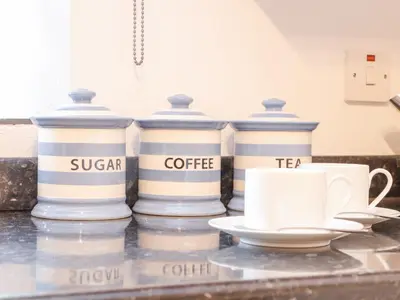 four blue and white containers sitting on a counter with cups at Riviere Barton in Hayle