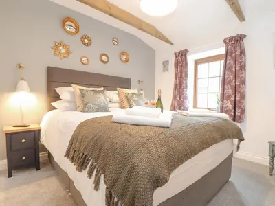 a bedroom with a large bed and a window at Riviere Barton in Hayle