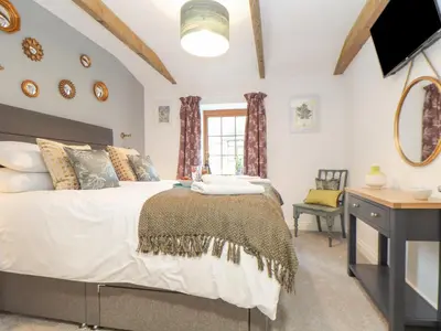 a bedroom with a bed and a desk and a window at Riviere Barton in Hayle