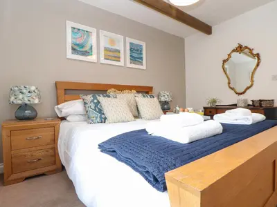 a bedroom with a large bed and a mirror at Riviere Barton in Hayle