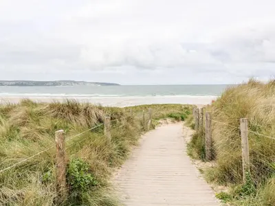a wooden path to a beach with the ocean at Riviere Barton in Hayle