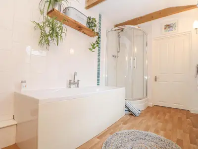 a white bathroom with a sink and a shower at Riviere Barton in Hayle