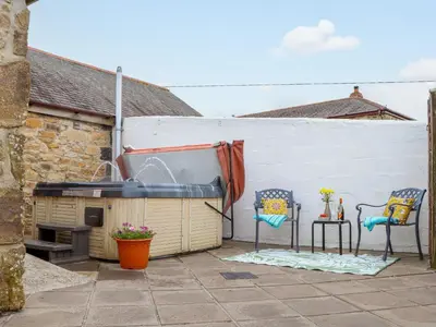 a patio with two chairs and a swimming pool at Riviere Barton in Hayle