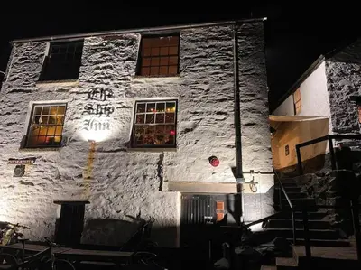 a white stone building with windows at night at Sea Whispers at Porthleven in Porthleven