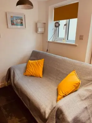 a bedroom with two yellow pillows on a bed at Sea Whispers at Porthleven in Porthleven