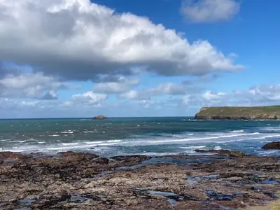 a view of the ocean with rocks in the water at Hollyhocks in Saint Minver