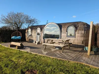 a wooden deck with two benches and a yurt at Jam First - Lydcott Glamping, Cornish Sea Views in East Looe