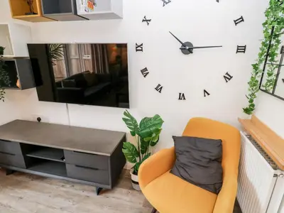 a living room with a chair and a desk and a mirror at 20 Bishops Way in Falmouth