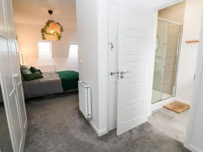 a bedroom with a bed and a door leading into a room at 20 Bishops Way in Falmouth