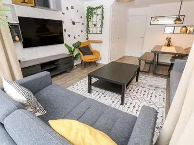 a living room with a blue couch and a table at 20 Bishops Way in Falmouth